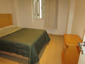 Un dormitorio con una cama verde y una ventana en South beach residence copacabana, en Río de Janeiro