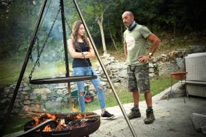 Un uomo e una donna in piedi accanto al fuoco di Ca-Jo Bed and Breakfast a Garessio