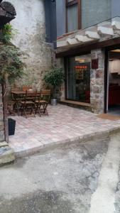 une terrasse avec une table et des chaises devant un bâtiment dans l'établissement Casas La Xiuca, à Corras de la Puente