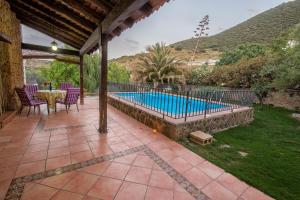 a patio with a table and chairs and a swimming pool at La Ventilla in Arbuniel