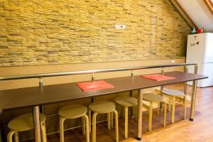 a table with four chairs and a brick wall at Rivyersky Hostel in Sochi