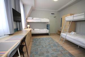 a dorm room with two bunk beds and a desk at Willa Park Apartamenty in Olsztyn +62 photos