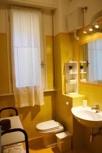 a yellow bathroom with a toilet and a sink at Renovated Central Suites in Florence