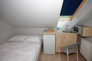 a small bedroom with a bed and a sink at Willa Park Apartamenty in Olsztyn