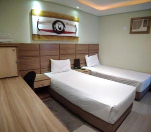 Un pat sau paturi într-o cameră la Hotel Luni