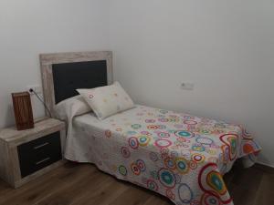 1 dormitorio con 1 cama con un edredón colorido en Vinaròs junto al mar, en Vinarós