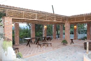 a pavilion with tables and benches on a brick patio at Guest House Daviti in Zestafoni