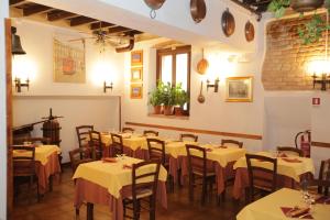 un restaurante con mesas y sillas blancas y una pared de ladrillo en La Fornasetta, en Milán