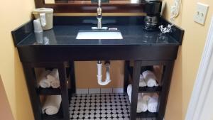 a bathroom vanity with a sink and a black counter at Dew Drop Inn in Forks