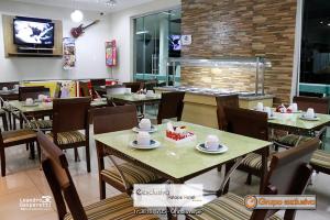 a restaurant with tables and chairs with cakes on them at Exclusiva Palace Hotel in Orindiúva