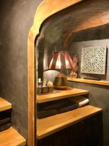 une lampe sur une étagère en bois dans une pièce dans l'établissement L’élégance au coeur du Médiéval, à Provins