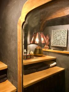 a lamp on a wooden shelf in a room at L’élégance au coeur du Médiéval in Provins