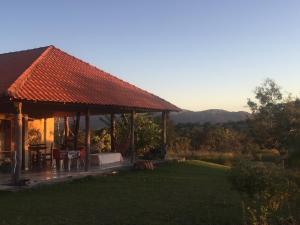 een huis met een tafel en stoelen in een tuin bij Chácara Canto da Mata in Cavalcante