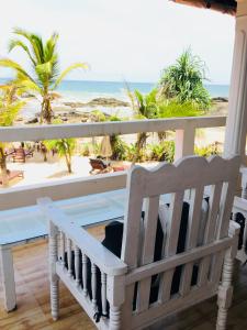 un banco en un porche con vistas a la playa en Villa Thotupola en Ahungalla