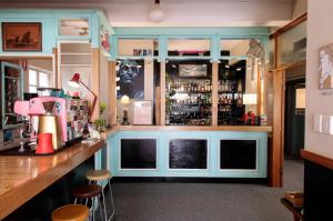 a bar with blue cabinets and stools at Alabama Hotel Hobart in Hobart