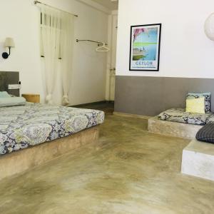 2 łóżka w pokoju z betonowymi podłogami w obiekcie Villa Thotupola w mieście Ahungalla