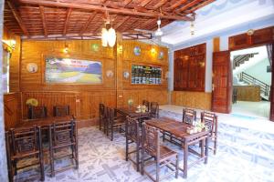ein Esszimmer mit Holzwänden und Tischen und Stühlen in der Unterkunft Tam Coc Cosiana Hotel in Ninh Bình