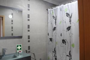 een badkamer met een douchegordijn en een wastafel bij Rias Apart in Vila Real de Santo António