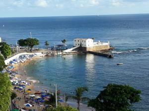 una playa con sombrillas y un edificio sobre el agua en EXCELENTE QUARTO DE HÓSPEDES PERTO DA PRAIA, en Salvador
