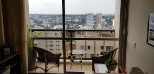 Habitación con vistas a un balcón con sillas y mesa. en Conforto, praticidade e seguranca!, en Curitiba