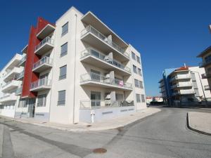 a white apartment building with balconies on a street at Pérola do Oeste - 3min da praia in São Martinho do Porto