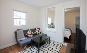 a living room with a couch and a table at Charming studio - 3 min walk to PETWORTH Metro station; 10 min to Convention Center in Washington, D.C.