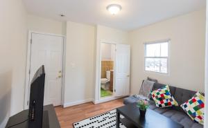 a living room with a couch and a tv at Charming studio - 3 min walk to PETWORTH Metro station; 10 min to Convention Center in Washington
