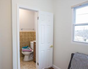 a bathroom with a toilet and a window at Charming studio - 3 min walk to PETWORTH Metro station; 10 min to Convention Center in Washington