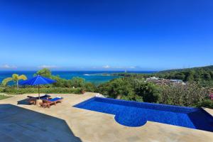 a swimming pool with a view of the water at Villa Kipas Retreat in Senggigi 