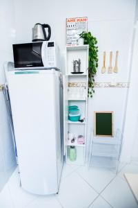 a white refrigerator with a microwave on top of it at Sossego na Cidade Baixa in Porto Alegre