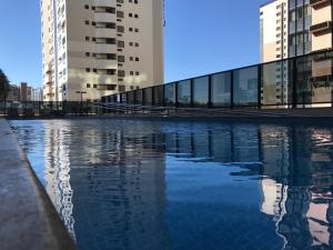 una piscina de agua frente a algunos edificios en flat no setor hoteleiro Norte wi-fi rápido, en Brasilia