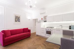 uma sala de estar com um sofá vermelho e uma cozinha em Be Home Rome em Roma