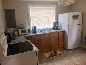 a kitchen with a white refrigerator and a sink at Rappahannock River Cottage Near I-95! in Fredericksburg