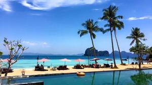 a view of a beach with palm trees and a pool at Thanya Beach Resort - SHA Plus in Ko Ngai