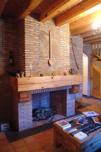 a living room with a stone fireplace with a sink at Casa Rural María Victoria in Navas de Estena