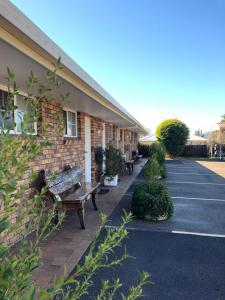 a building with benches in front of a building at Golden Grain Motor Inn in Tamworth
