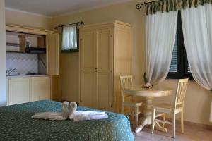 a bedroom with a bed and a dresser at Hotel Villa Del Parco in La Maddalena