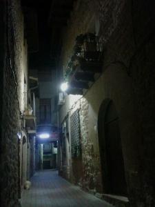 a narrow alleyway with a clock on the wall at Hostal Can Barrina in Arnés