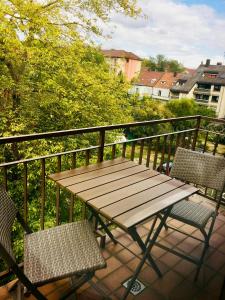 einen Holztisch und zwei Stühle auf dem Balkon in der Unterkunft Modernes Studio im Herzen von Neustadt: PfalzLiebe in Neustadt an der Weinstraße