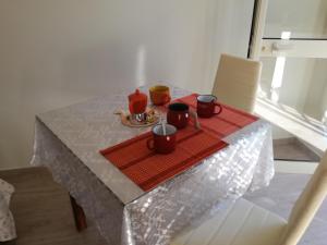 a table with a plate of food and cups on it at La Cycas Accommodation in Tropea +32 photos