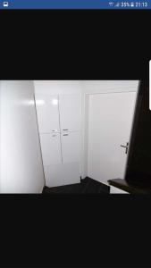 カップ・ダグドにあるBlack loftの白いキャビネット2つとドアが備わる部屋