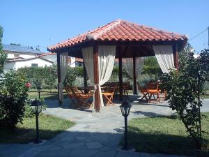 a pavilion with a table and chairs in a yard at Hotel Koukouli in Souflíon