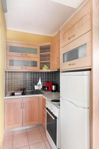 a kitchen with wooden cabinets and a white refrigerator at Giorgi's Blue Apartments in Kalathas