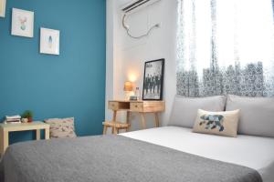 una camera da letto con un letto con pareti blu e una finestra di Lazy House a Città di Hualien