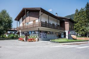 a building with a balcony on the side of a street at Appartements Drei Zinnen in San Candido