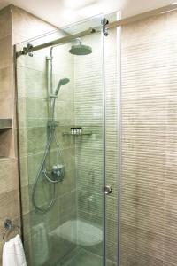 a shower stall with a glass shower door at Hotel Garnet Tbilisi in Tbilisi City
