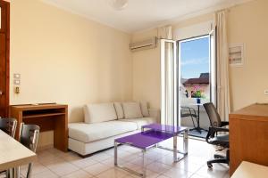 a living room with a couch and a table at Giorgi's Blue Apartments in Kalathas