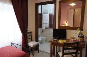 a room with a bathroom with a desk and a television at B&B Liolà in Agrigento