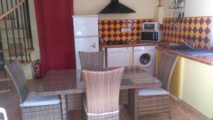 uma cozinha com uma mesa e cadeiras numa cozinha em Gite Les Oliviers em Cotignac