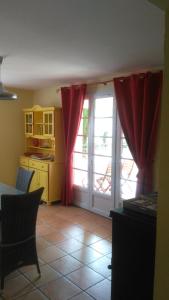 uma cozinha com cortinas vermelhas e uma cozinha com uma porta em Gite Les Oliviers em Cotignac